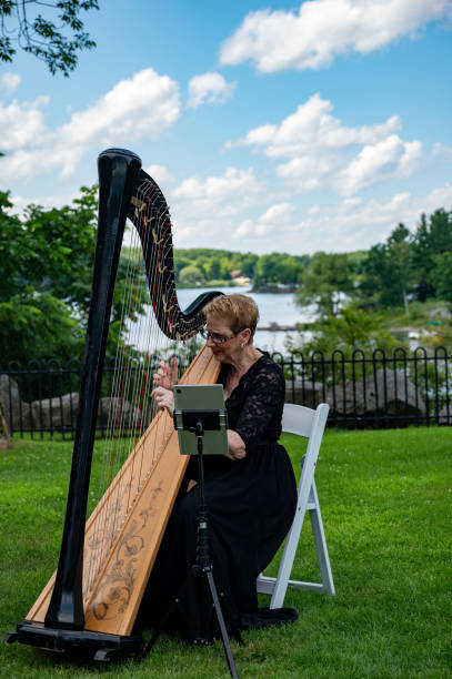 A Japanese female harpist is playing harp in a garden.