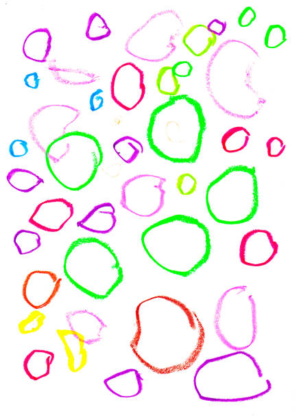 Above shot and close up of child’s hand drawing with crayons on paper on the floor