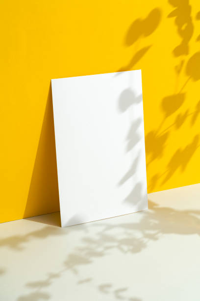 istock White blank paper mockup on yellow background with floral shadows 2163796229