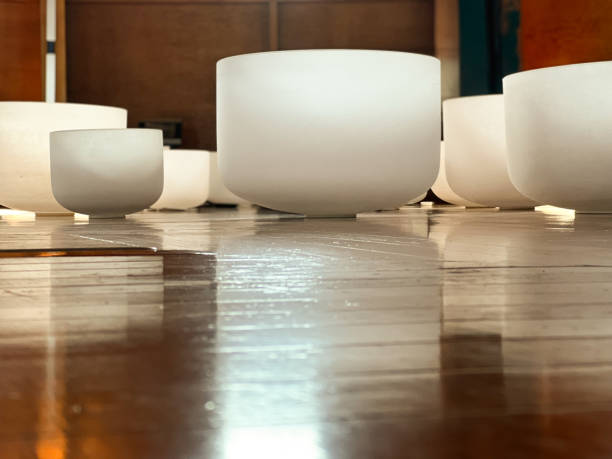 White singing bowls on a hard wood floor ready for sound bath