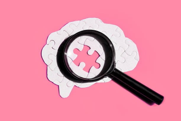 istock Brain Puzzle and Magnifying Glass on Pink Backdrop 2163804400