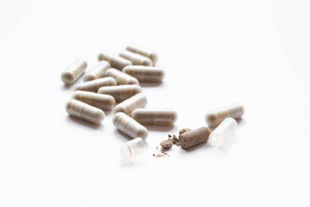 Close shot of three beige round pills of iron bisglycinate dietary supplement