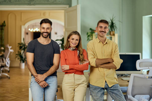 istock Three business colleagues smiling for the camera, standing in the co-working space. 2163805236