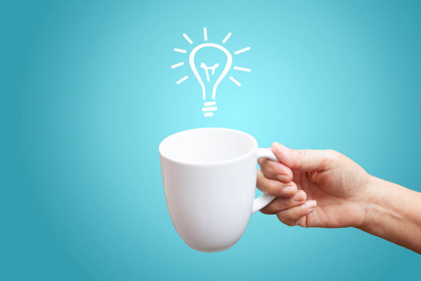a cup of coffee and light bulb on a blue background. creativity and a new idea concept