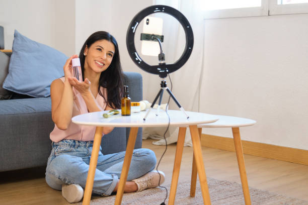 istock Influencer smiling and showing beauty product while recording video 2163805955