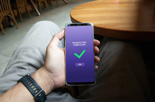 istock Transaction completed notification in a mobile phone screen, blurred coffee shop background 2163806041