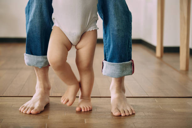 istock A son's feet taking the first steps with his father 2163812082
