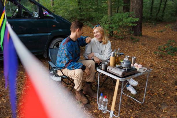 istock Couple's Serene Escape: Relaxing by the Camper in Nature 2163824360