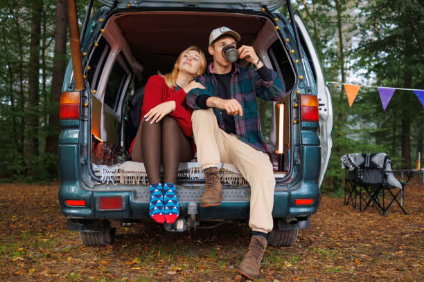 istock Peaceful Forest Scene: Couple Unwinds in Rustic Camper 2163825355