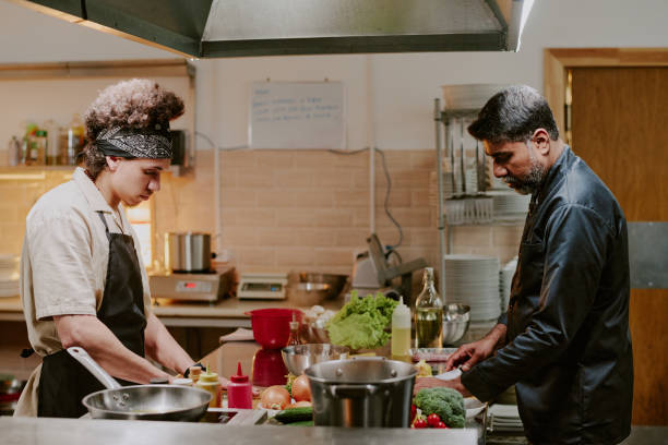 istock Chef and Sous Chef Cooking Dishes Together 2163828980