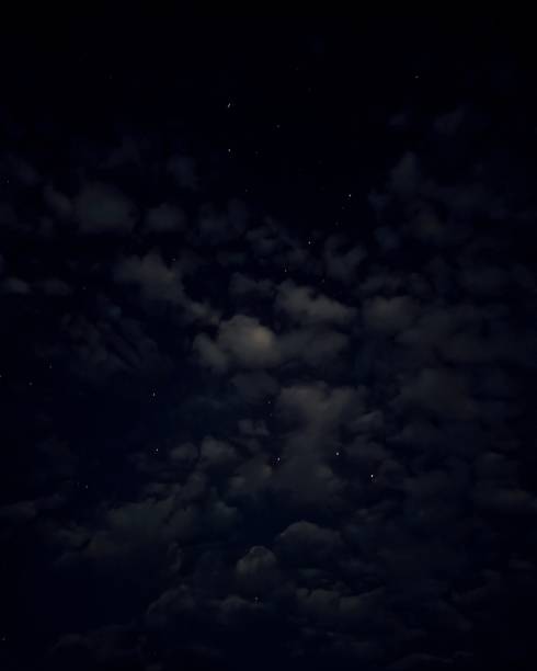 Black, dark blue night sky. Stars. White cumulus clouds. Background