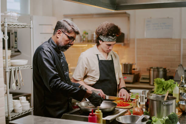 istock Chef and Sous Chef Cooking Together in Kitchen 2163829596
