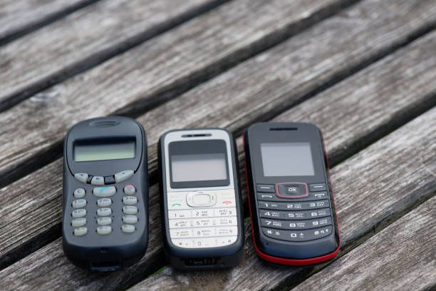 Obsolete cell phones on old weathered wooden table