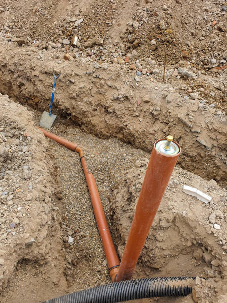 istock Drainage testing equipment placed next to a drainage pipe in an excavated trench. Site preparation and ground excavation concept. 2163835915