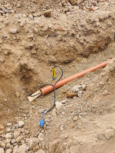 istock Drainage testing equipment placed next to a drainage pipe in an excavated trench. Site preparation and ground excavation concept. 2163835920