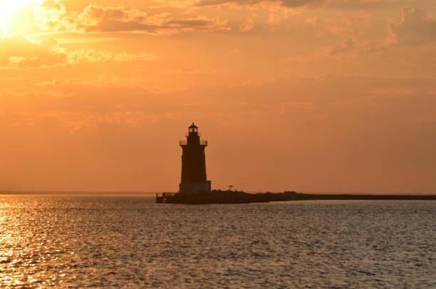 istock Delaware Breakwater Lighthouse at Cape Henlopen State Park at sunset with vibrant orange cloudscape 2163836597