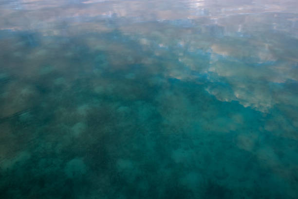 istock Clouds reflecting on tranquil water in the sea 2163839420