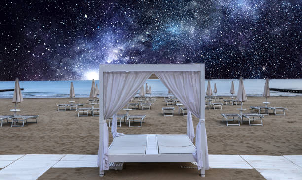 Lounger with canopy on the beach under the romantic starry sky.