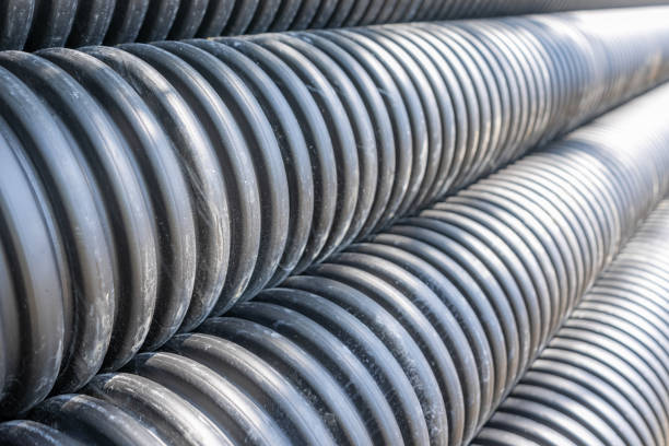 istock Stack of black HDPE storm sewer pipe (HDPE plastic N-12) on a project site awaiting installation. 2163839919