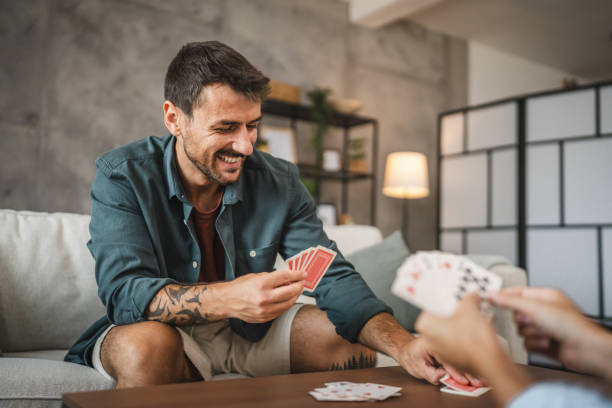 istock Boyfriend sit on sofa and play card at home 2163846116