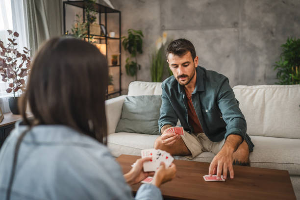 istock Serious man sit on sofa and play card and think about the next move 2163846235