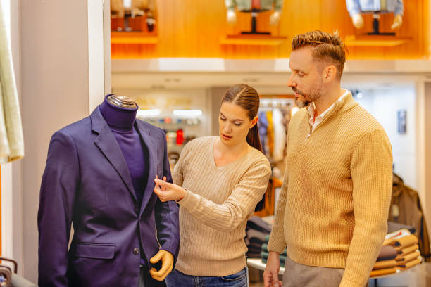 istock Young couple browsing suits in a clothing store 2163846529