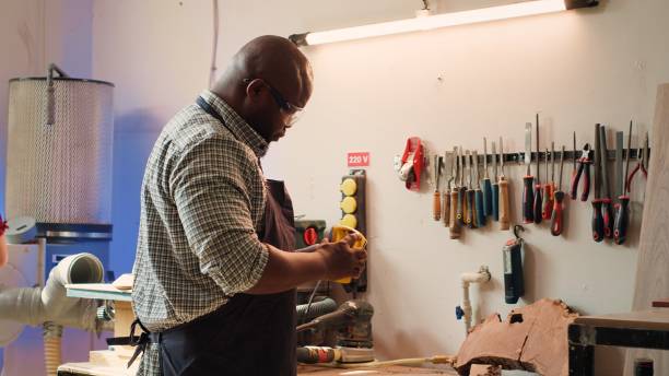 istock Artisan in studio using sandpaper for smoothing wooden surface 2163847498