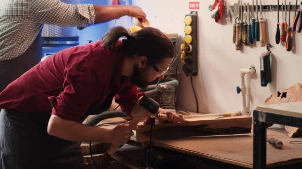 istock Woodworker using bench vise to hold lumber block, carving intricate designs 2163847806