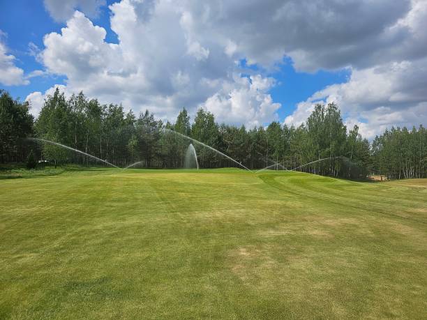 istock Sprinklers water green grass on a sunny day on a golf course 2163866301