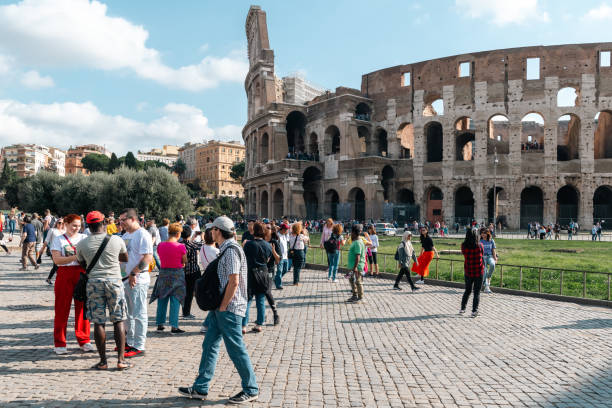 Rome, Italy - October 1, 2019: Tourists flock to the ancient Colosseum under clear blue skies.