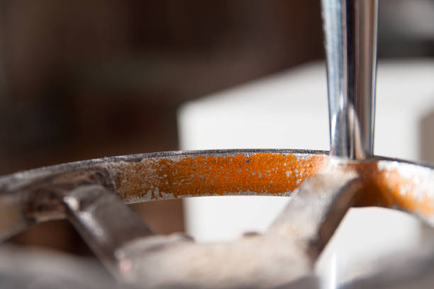 Close up of a rusty metal tool resting on a workbench, with a shallow depth of field emphasizing the texture and detail of the metal