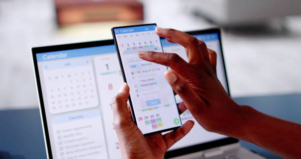 istock African Woman Organizing Appointment Schedule Using Cellphone And Calendar 2163868489