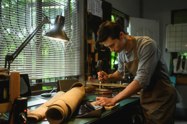 istock Focused male tailor working meticulously in a leather workshop. Small business and handmade concept 2163870939