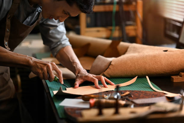 istock An artisan carefully using a sharp knife to shape the leather on cutting mat in his workshop 2163870965