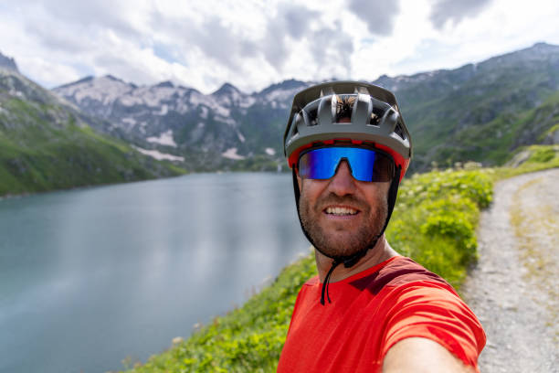 istock Male Cyclist Taking Selfie by Mountain Lake 2163875849