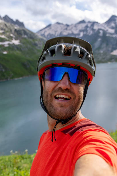 istock Male Cyclist Taking Selfie by Mountain Lake 2163875850