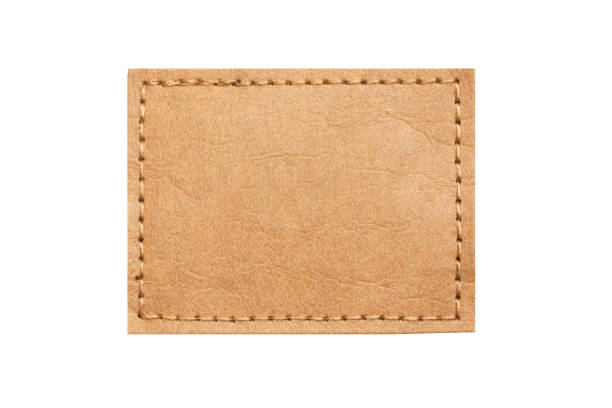 istock Brown leather belt strap closeup isolated on white. Brown stitched leather seam frame label tag isolated on white. Sewing background. 2163880395