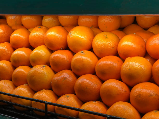 istock fresh ripe oranges neatly stacked in a grocery store display 2163886444