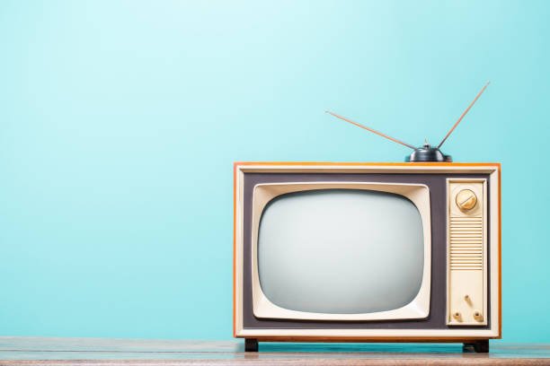 istock Retro TV receiver frame with antenna on wooden table front gradient mint blue background. Vintage style filtered photo 2163891616