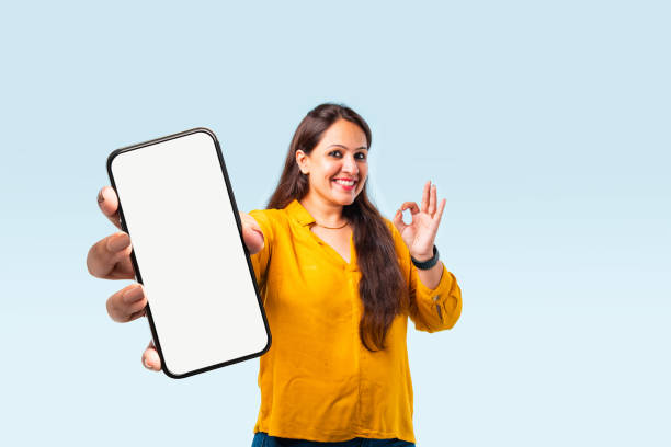 istock Indian asian young woman showing big smartphone with empty screen 2163894638