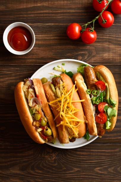 istock Hot dogs with different toppings on wooden background 2163896902