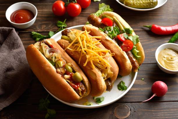 istock Hot dogs with different toppings on wooden table 2163896959