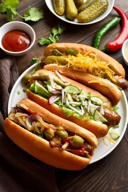 istock Hot dogs with different toppings on wooden table 2163896965