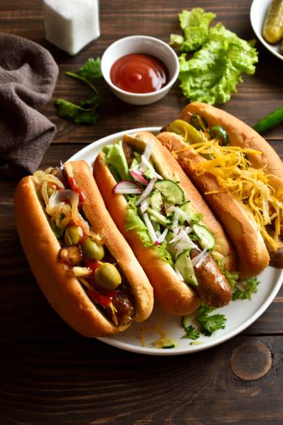 istock Hot dogs with different toppings on wooden table 2163897074