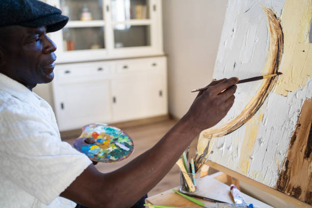 istock Pensioner artist painting on canvas at his studio 2163897728