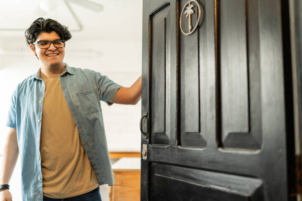 istock Young man opening the door at home 2163899140