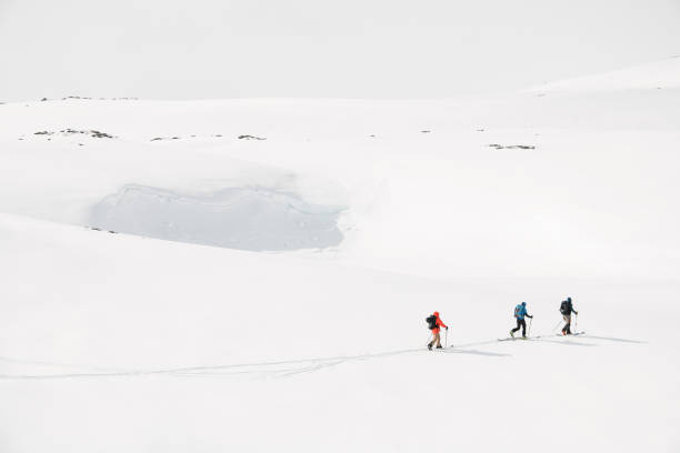 istock Three skiers move quickly on skis one after the other, leaving a ski trail 2163902178