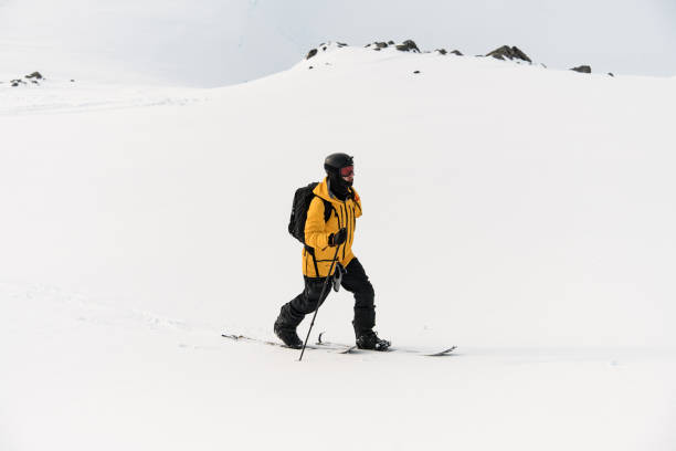 istock One-armed confident skier is skiing against a white snowy background 2163904430