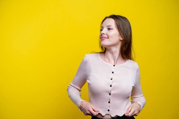 Woman looking to the side on yellow background.