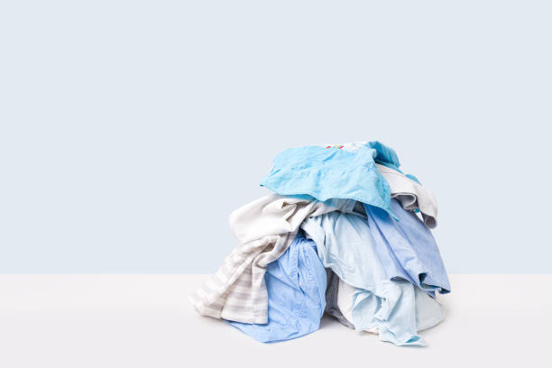 istock Stack of dirty clothes waiting for laundry isolated on light blue background 2163905510